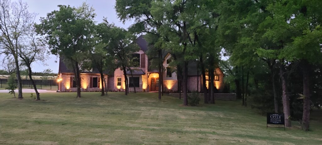 A Large House Illuminated by Warm Lights, Creating a Cozy Atmosphere During the Evening Hours.